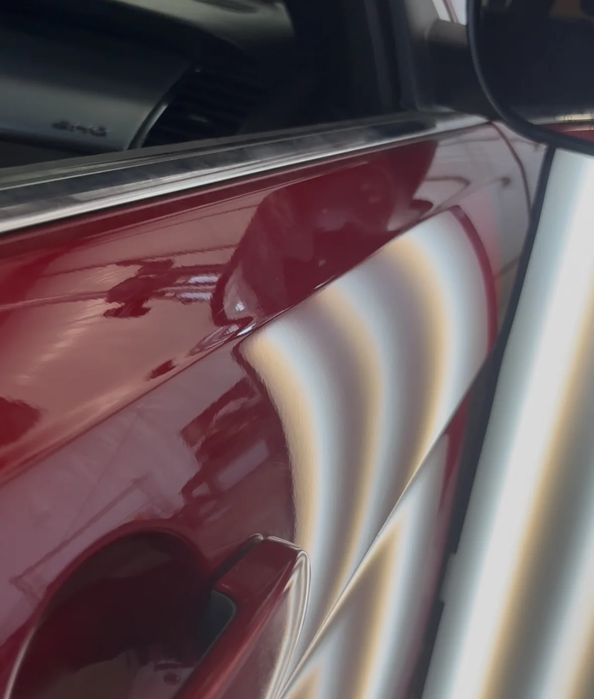 After repair: straighter reflection lines across the repaired red vehicle door