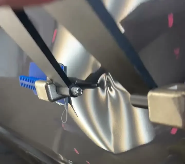 A dented vehicle door under PDR lighting and precision pulling tools