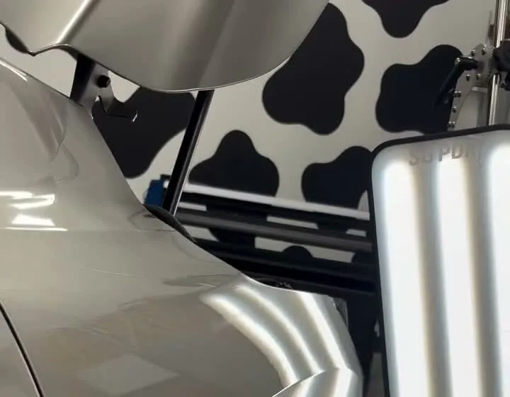 A silver vehicle panel being inspected with a PDR light